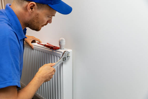 house heating system installation plumber installing radiator - heating engineer imagens e fotografias de stock