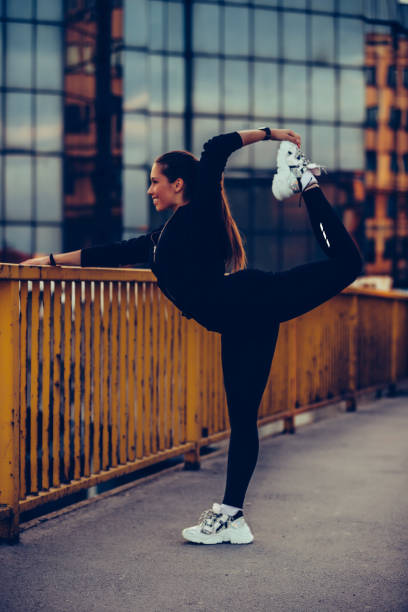istock Girl warming up on river bridge, preparing for evening workout 1160015559