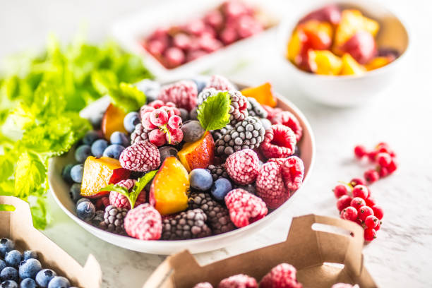 istock Frozen fruits blueberries blackberry raspberry red currant peach and herbs melissa 1160015645