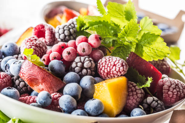 istock Frozen fruits blueberries blackberry raspberry red currant peach and herbs melissa 1160015681