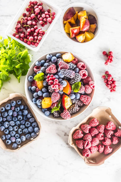 istock Frozen fruits blueberries blackberry raspberry red currant peach and herbs melissa 1160015686