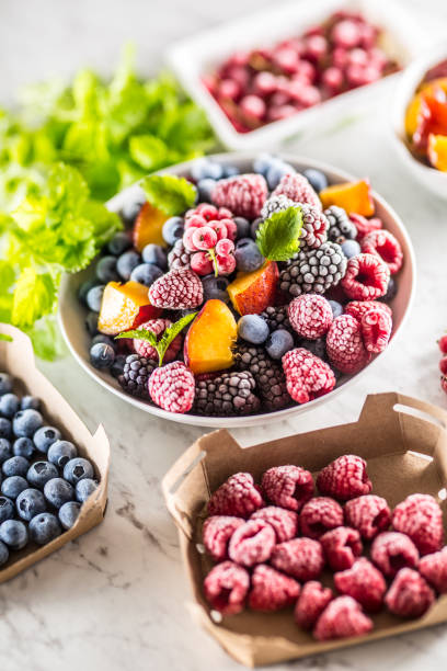 istock Frozen fruits blueberries blackberry raspberry red currant peach and herbs melissa 1160015687