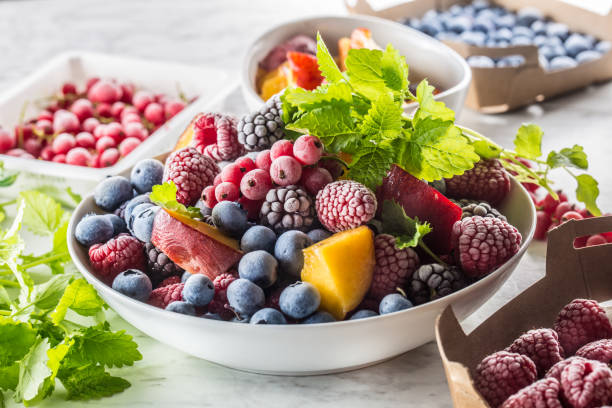 istock Frozen fruits blueberries blackberry raspberry red currant peach and herbs melissa 1160015688