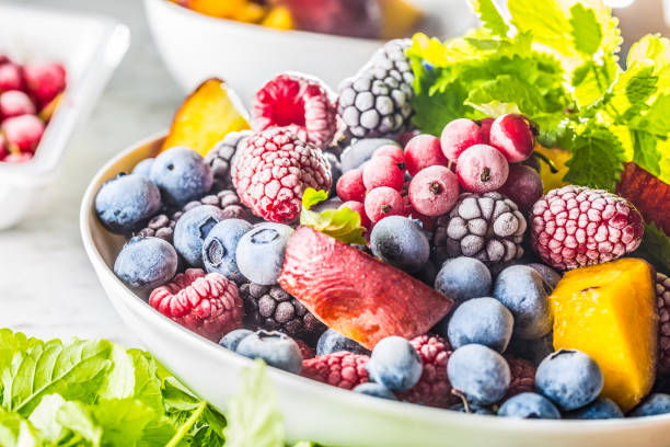 istock Frozen fruits blueberries blackberry raspberry red currant peach and herbs melissa 1160015691