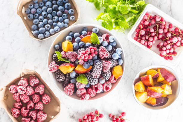 istock Frozen fruits blueberries blackberry raspberry red currant peach and herbs melissa 1160015696