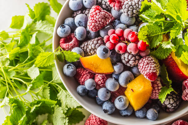 istock Frozen fruits blueberries blackberry raspberry red currant peach and herbs melissa 1160015701