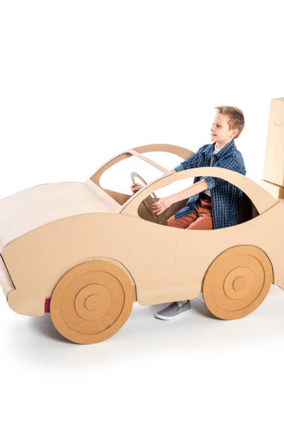 istock adorable boy playing with cardboard car on white with copy space 1160018146