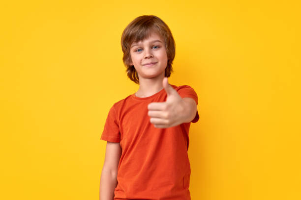 cheerful boy gesturing thumb up - congratulating winning agreement thumbs up imagens e fotografias de stock