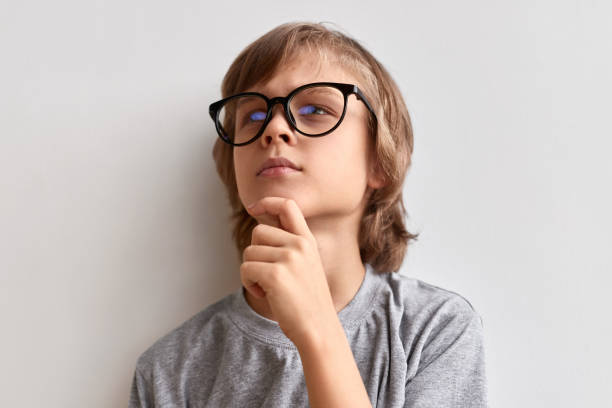 istock Thoughtful schoolboy rubbing chin 1160023889
