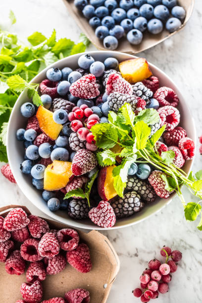 istock Frozen fruits blueberries blackberry raspberry red currant peach and herbs melissa 1160024305