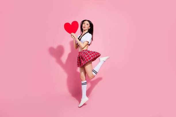 Profile side full length body size view of her she nice-looking attractive slim cheerful straight-haired lady having fun holding in hands large heart sending kiss isolated on pink pastel background