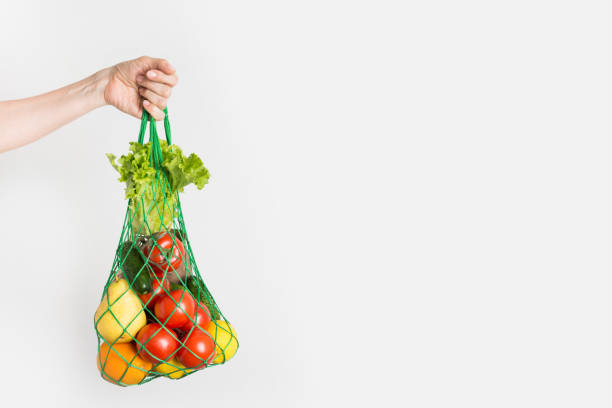 мешок с фруктами, овощами, зеленью в женской руке. нулевые отходы. пластик бесплатный. - duty free стоковые фото и изображения