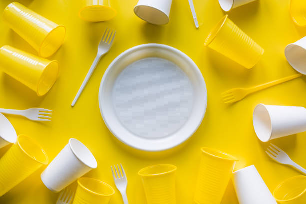 istock Disposable white picnic utensils for recycling on yellow. Top view. Flat lay. 1160029214