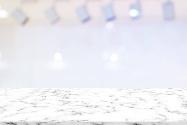 istock blurred white stage with LED spotlight background with marble texture tabletop for ads design,show,promote on display 1160033552