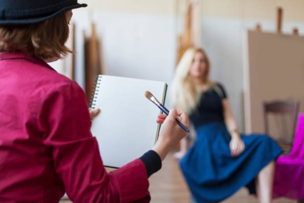 young female model posing to professional painter