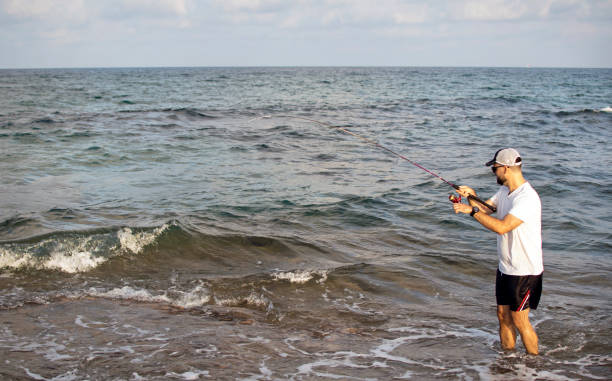 istock Fisherman standing at the seashore hooks a fish. 1160037074