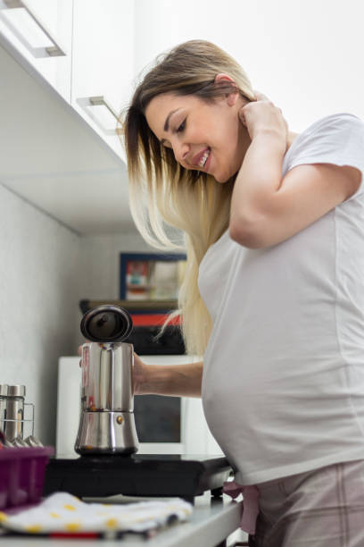 istock Happy young pregnant woman making coffee 1160037371