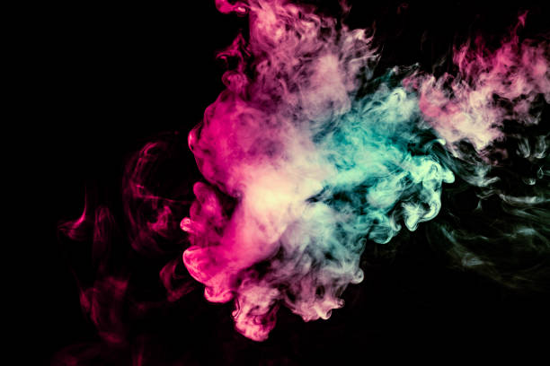 istock Colored background with winding clouds of smoke from patterns of different forms of pink, green and blue colors with tongues of flame on a black isolated background 1160038691
