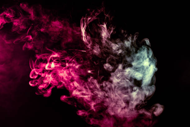 istock Colored background with winding clouds of smoke from patterns of different forms of pink, green and blue colors with tongues of flame on a black isolated background 1160038715