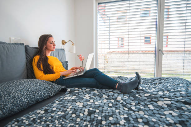 istock Beautiful woman using laptop on bed at home 1160039149