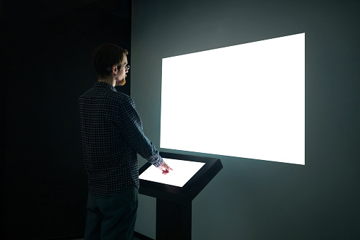 Hombre mirando blanco blanco gran pantalla de pared interactiva - imagen de maqueta photo