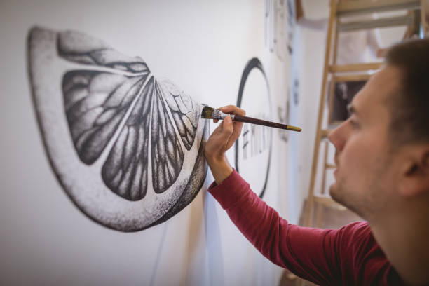 istock Focused artist painting on the wall 1160039717