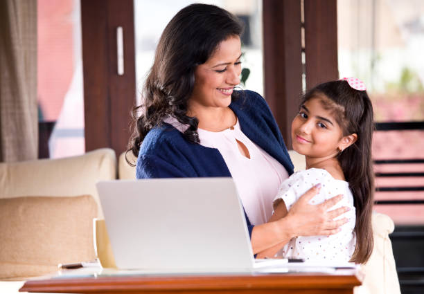 istock Working mother embracing her daughter at home 1160040327