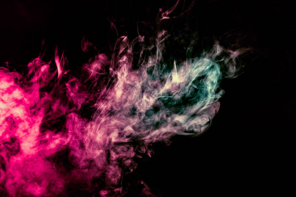 istock Colored background with winding clouds of smoke from patterns of different forms of pink, green and blue colors with tongues of flame on a black isolated background 1160040635