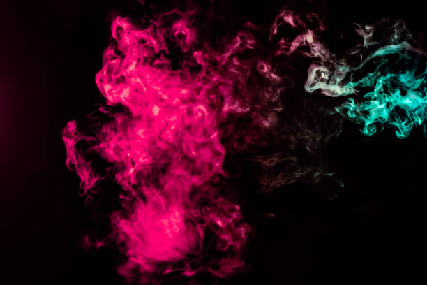 istock Colored background with winding clouds of smoke from patterns of different forms of pink, green and blue colors with tongues of flame on a black isolated background 1160040752