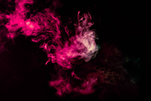 istock Colored background with winding clouds of smoke from patterns of different forms of pink, green and blue colors with tongues of flame on a black isolated background 1160040844