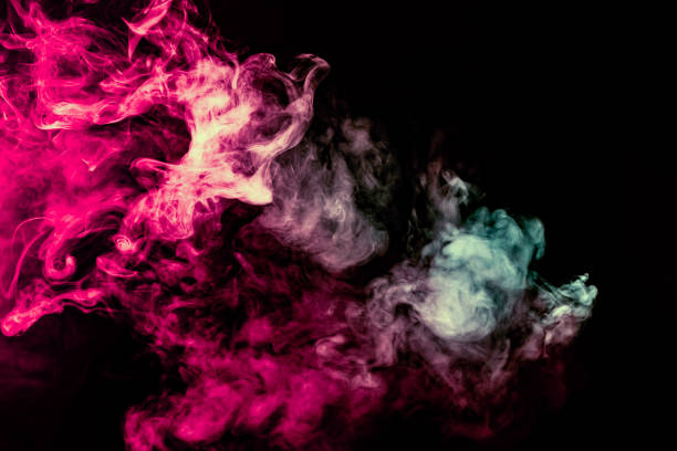 istock Colored background with winding clouds of smoke from patterns of different forms of pink, green and blue colors with tongues of flame on a black isolated background 1160040872