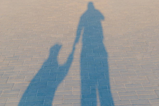 The shadow of an adult male and child girls - dad and daughter. The shadow of an adult male and child girls - dad and daughter kidnapping photos stock pictures, royalty-free photos & images