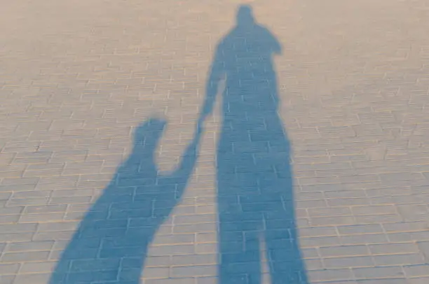 The shadow of an adult male and child girls - dad and daughter