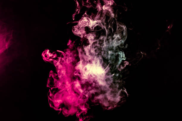istock Colored background with winding clouds of smoke from patterns of different forms of pink, green and blue colors with tongues of flame on a black isolated background 1160041090