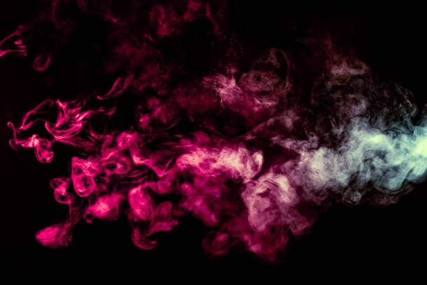 istock Colored background with winding clouds of smoke from patterns of different forms of pink, green and blue colors with tongues of flame on a black isolated background 1160041148