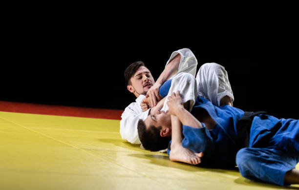 istock Male Judo Player Choking His Sparring Partner With Legs 1160043721
