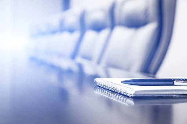 istock Meeting room with notepad and pen on table. Color toning with light flare 1160044485