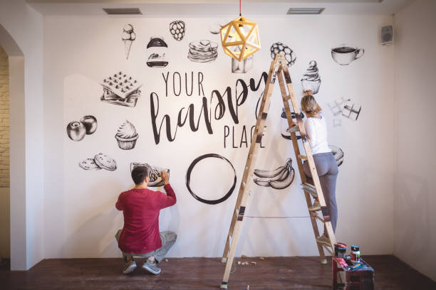 istock Dedicated couple of illustrators working on a wall 1160045055