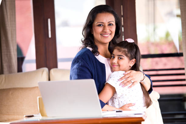 Working mother embracing her daughter at home