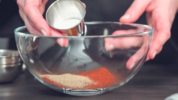 istock Mixing together spice rub in glass mixing bowl. 1160047822