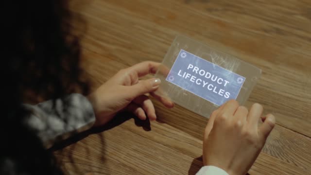 Hands hold tablet with text Product lifecycles