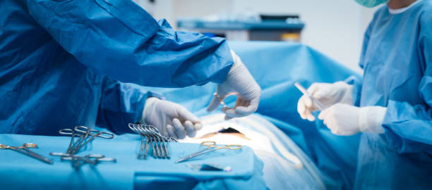 medico e infermiere in sala operatoria con paziente sul tavolo operatorio in ospedale - operazione di trapianto foto e immagini stock