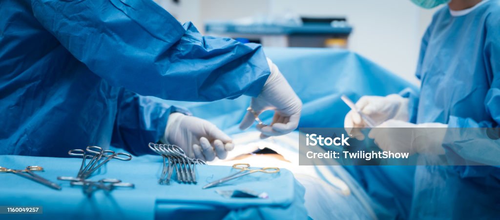 Doctor and nurse in the operating room with patient on the operating table in hospital Doctor and nurse in the surgery room with a patient Surgery Stock Photo