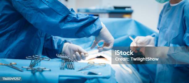 Doctor And Nurse In The Operating Room With Patient On The Operating Table In Hospital Stock Photo - Download Image Now