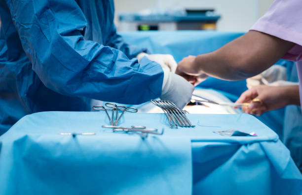 Doctor and nurse in the operating room with patient on the operating table in hospital stock photo