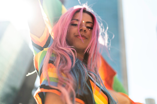 Retrato de mujer sosteniendo bandera arco iris durante LGBTQI photo