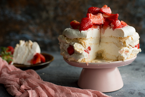 Creamy refreshing fruit cake with biscuits, vanilla cream, bananas and raspberries, decorated with white whipped cream. Served in cake trays