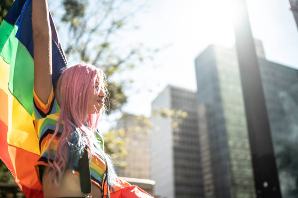 istock Woman holding rainbow flag during LGBTQI parade 1160050843