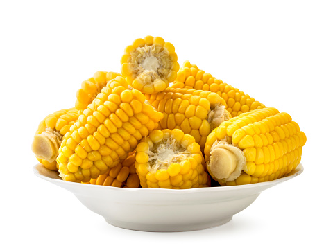 Boiled corn in a plate close up on a white background, isolated.