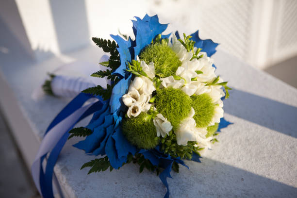 istock Wedding bouquet in white and green colors and blue decoration on a white surface 1160051549